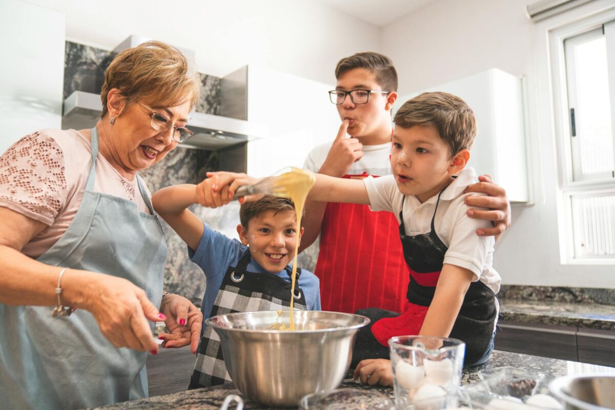 smimling grandmother and grandsons cooking
