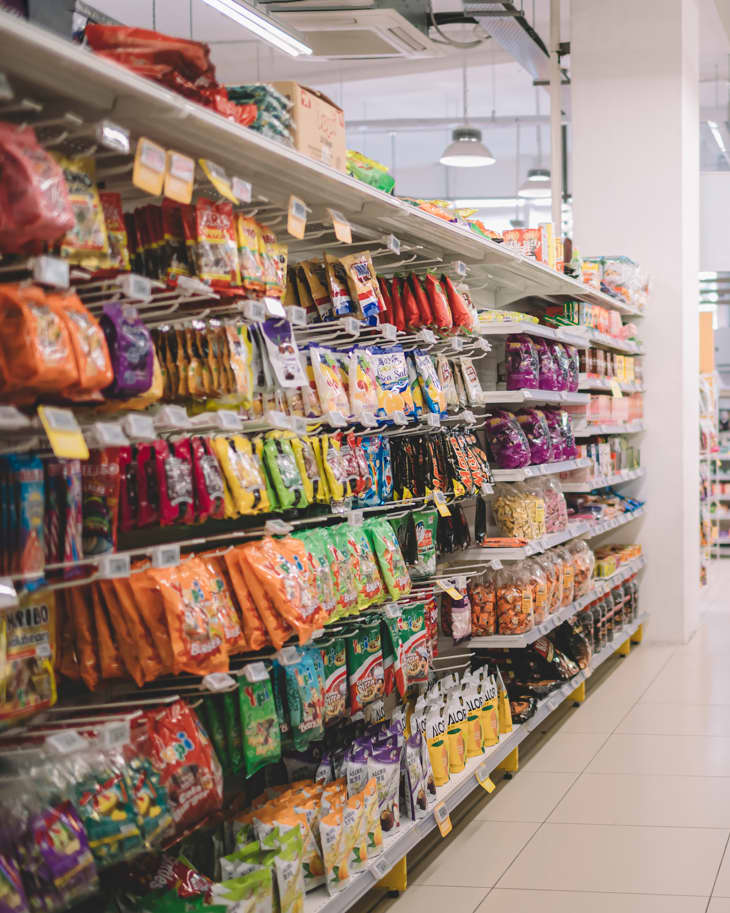 Interior of supermarket full of grocery items in rows with shelf displayed